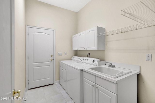 laundry area with light tile patterned flooring, independent washer and dryer, a sink, and cabinet space