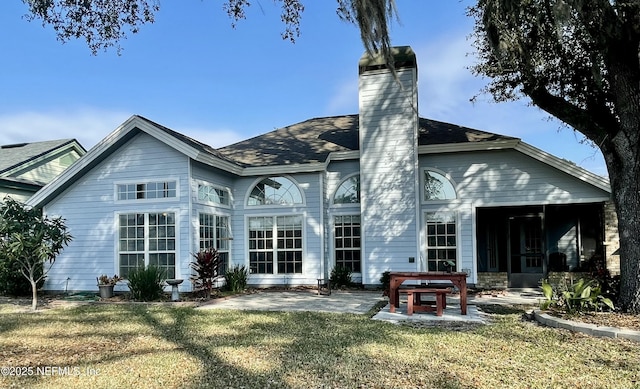 rear view of property featuring a patio area and a lawn