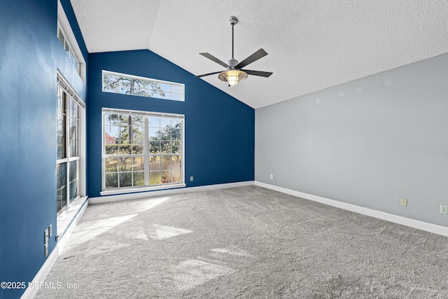 carpeted empty room featuring ceiling fan, high vaulted ceiling, and a textured ceiling