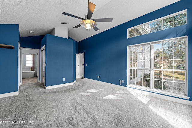 unfurnished bedroom with carpet flooring, vaulted ceiling, and a textured ceiling