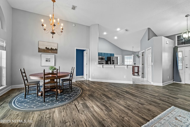 dining space featuring dark hardwood / wood-style floors, a notable chandelier, and high vaulted ceiling