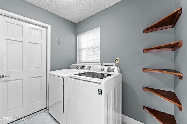 laundry room with independent washer and dryer and a textured ceiling