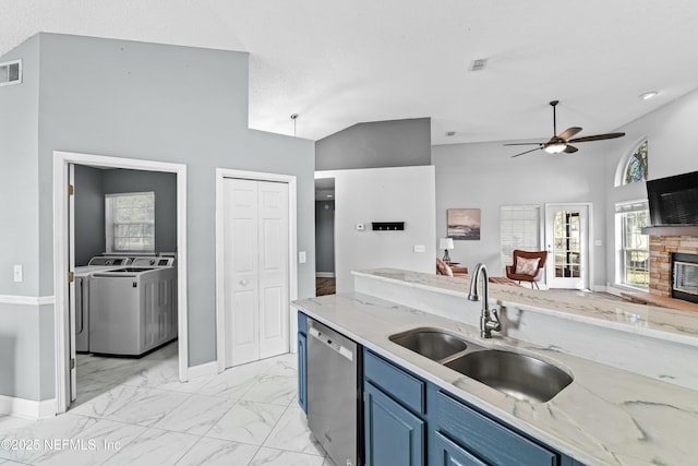 kitchen featuring sink, blue cabinetry, dishwasher, light stone countertops, and separate washer and dryer