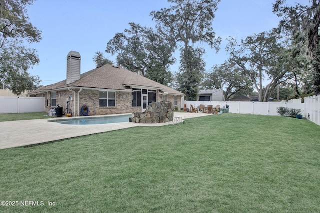 back of house featuring a yard, a fenced in pool, and a patio