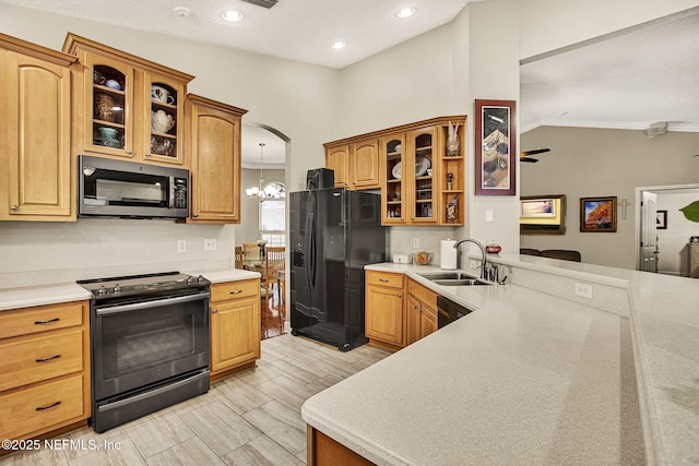 kitchen with lofted ceiling, sink, a chandelier, hanging light fixtures, and black appliances