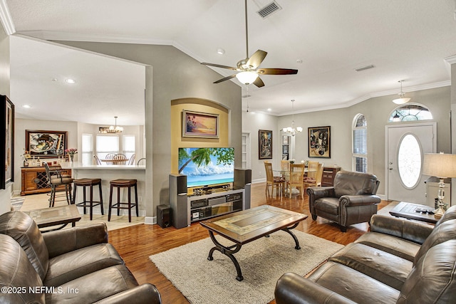 living room featuring crown molding, vaulted ceiling, light hardwood / wood-style floors, and ceiling fan with notable chandelier