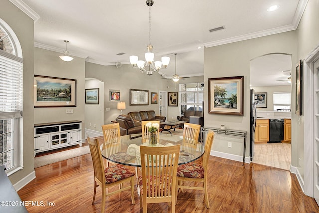 dining space with crown molding, ceiling fan with notable chandelier, and light wood-type flooring