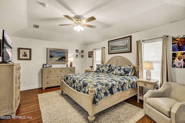 bedroom featuring ceiling fan, dark hardwood / wood-style floors, and a textured ceiling