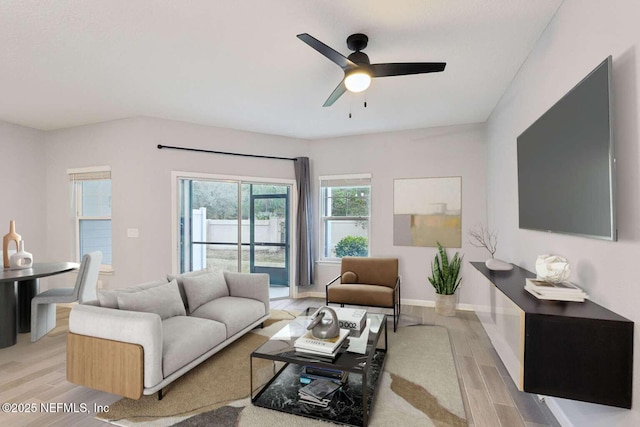 living room featuring light hardwood / wood-style flooring and ceiling fan