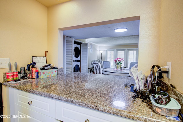 kitchen with white cabinetry, stone countertops, and a textured ceiling