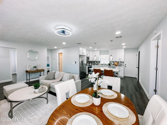 dining room with dark wood-type flooring, sink, and a textured ceiling