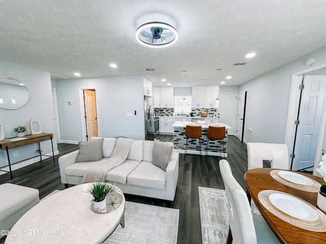 living room featuring a textured ceiling and dark hardwood / wood-style flooring