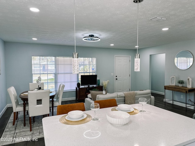 dining room with dark hardwood / wood-style flooring and a textured ceiling