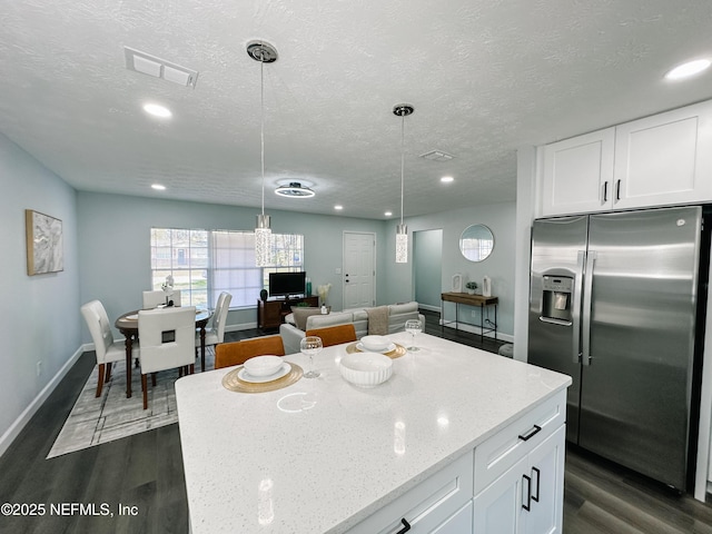 kitchen with decorative light fixtures, white cabinets, and stainless steel fridge with ice dispenser