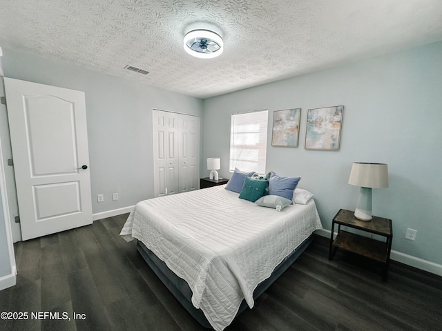 bedroom with dark wood-type flooring, a closet, and a textured ceiling