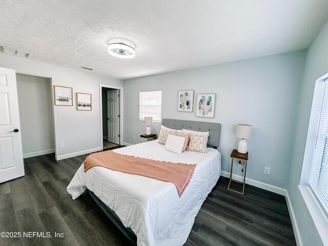 bedroom with dark wood-type flooring and a textured ceiling