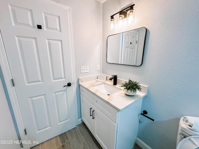 bathroom featuring vanity, washer / dryer, and toilet