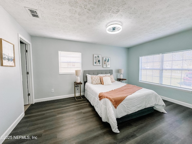 bedroom featuring dark wood-type flooring and a textured ceiling