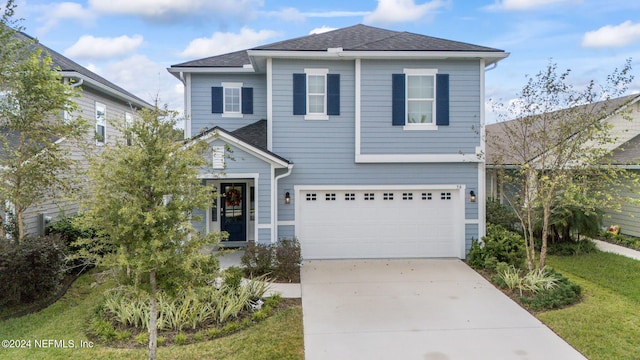 view of front of property featuring a garage and a front lawn