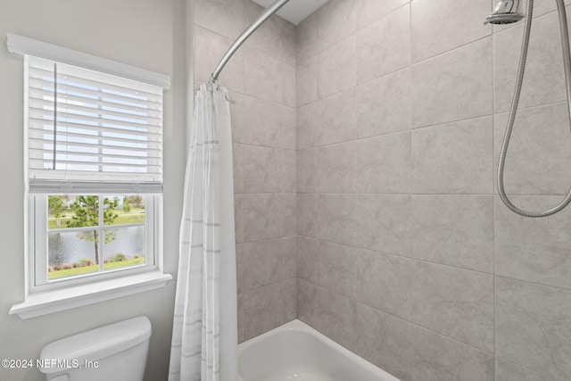 bathroom featuring shower / tub combo with curtain and toilet