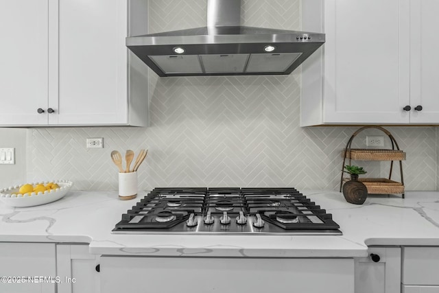 kitchen with white cabinetry, extractor fan, light stone countertops, stainless steel gas cooktop, and decorative backsplash