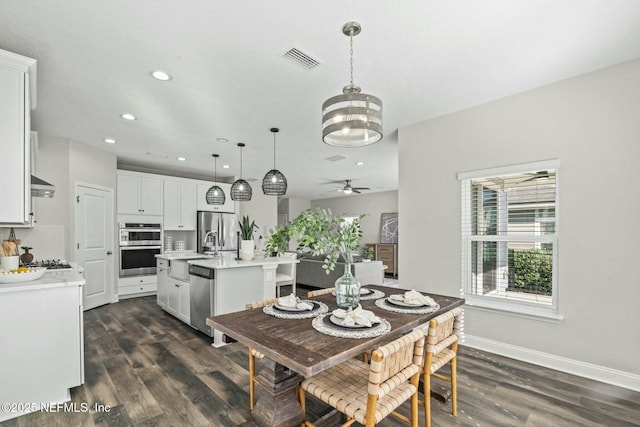 dining room featuring sink, dark hardwood / wood-style flooring, and ceiling fan with notable chandelier