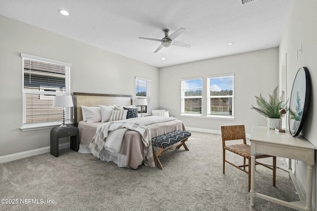 carpeted bedroom with ceiling fan and a textured ceiling