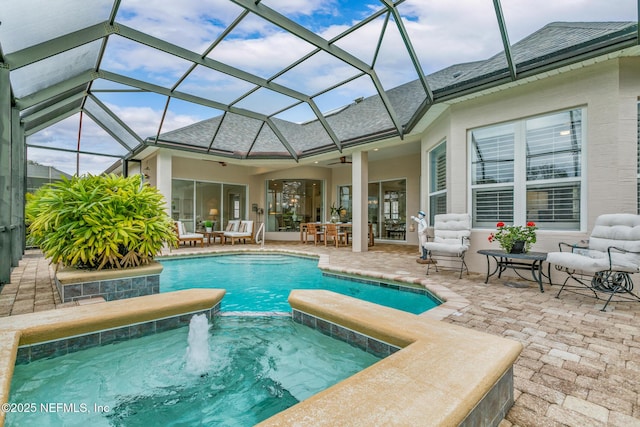 view of pool with a patio, outdoor lounge area, pool water feature, ceiling fan, and glass enclosure