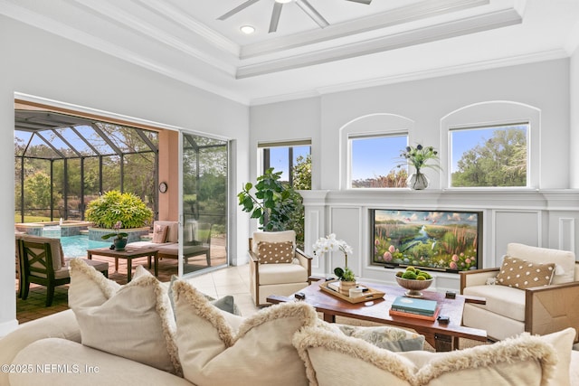 2095 Crown Dr, Saint Augustine, FL 32092 - living room featuring a decorative wall, crown molding, a ceiling fan, a healthy amount of sunlight, and a tray ceiling