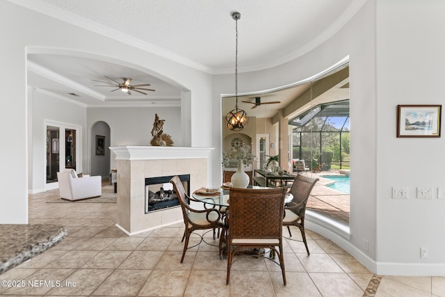 2095 Crown Dr, Saint Augustine, FL 32092 - dining area featuring baseboards, crown molding, ceiling fan, and a tiled fireplace