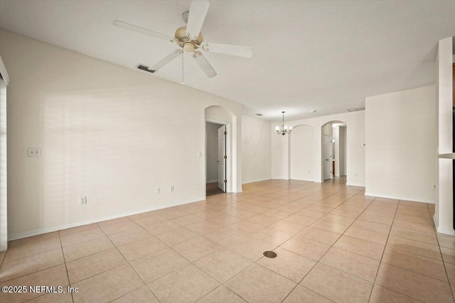 empty room with light tile patterned flooring and ceiling fan with notable chandelier