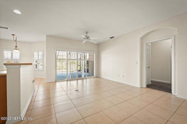 spare room with light tile patterned floors, a textured ceiling, and ceiling fan