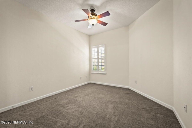 unfurnished room with ceiling fan, dark carpet, and a textured ceiling