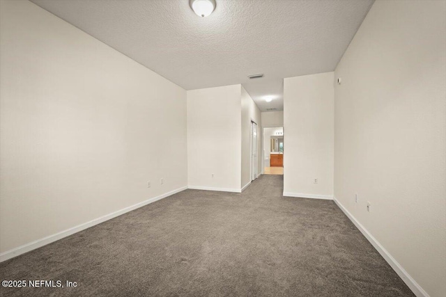 carpeted empty room featuring a textured ceiling