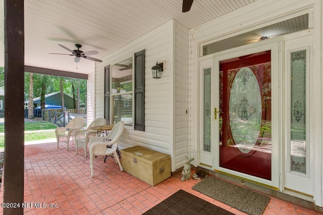 doorway to property with a porch and a ceiling fan