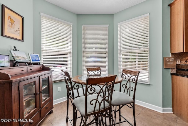 dining area featuring plenty of natural light, baseboards, and light tile patterned flooring