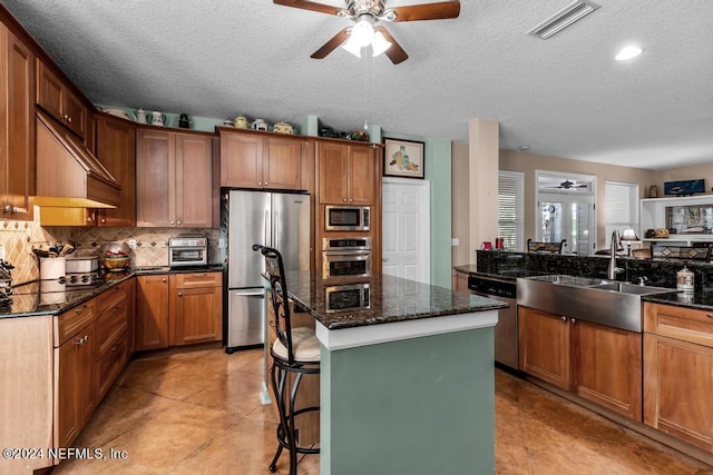 kitchen with tasteful backsplash, visible vents, a center island, stainless steel appliances, and a sink