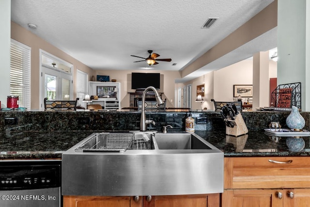 kitchen featuring visible vents, dishwasher, open floor plan, a textured ceiling, and a sink