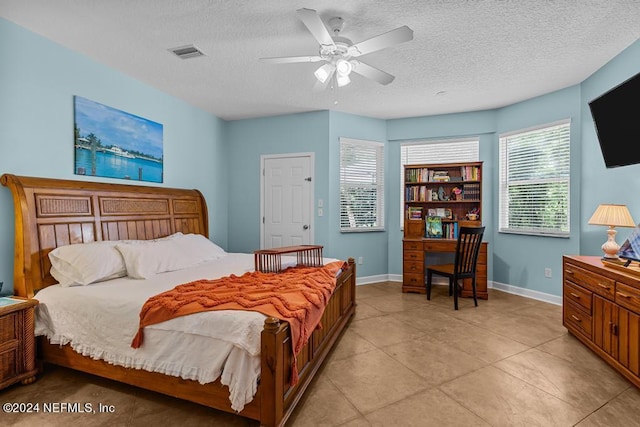 bedroom featuring baseboards, visible vents, ceiling fan, and a textured ceiling