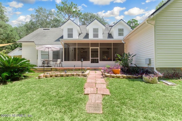 rear view of house with a sunroom and a lawn