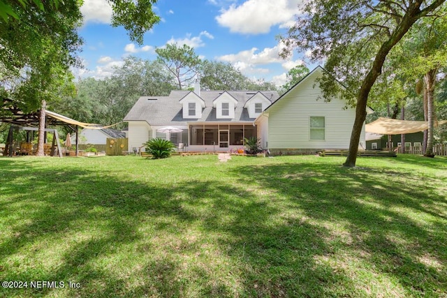 back of property featuring a lawn and a sunroom