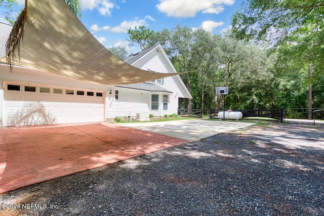 view of front of property with driveway, an attached garage, and fence