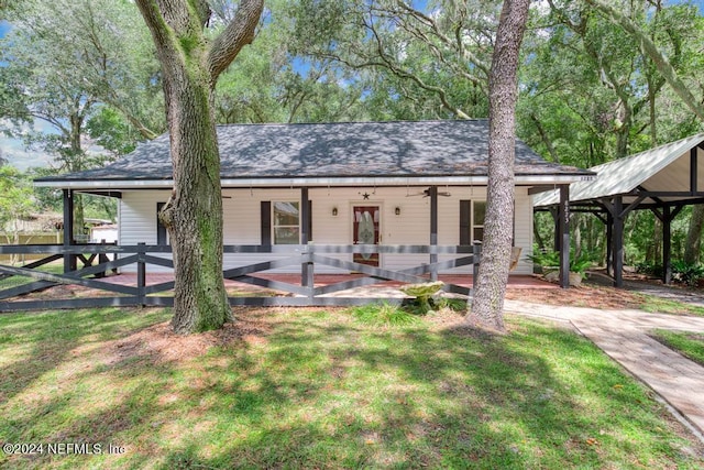 view of front of property featuring a shingled roof, a front yard, fence, and a wooden deck