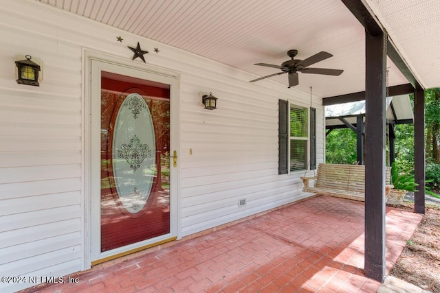 doorway to property with covered porch and ceiling fan