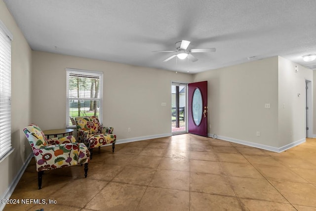 foyer featuring baseboards, ceiling fan, and a healthy amount of sunlight