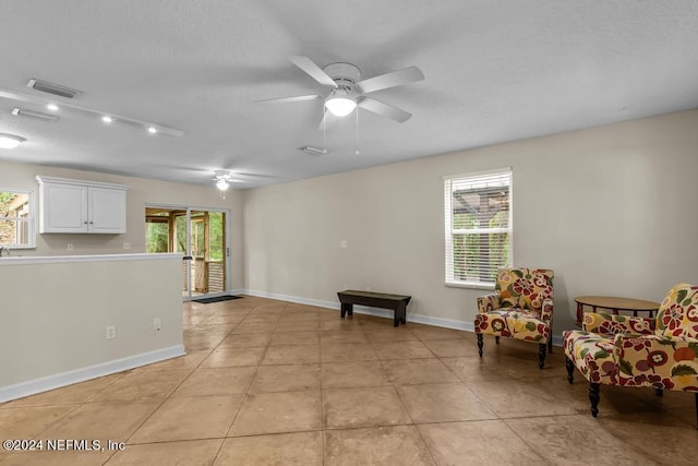 sitting room featuring a healthy amount of sunlight, visible vents, baseboards, and light tile patterned floors