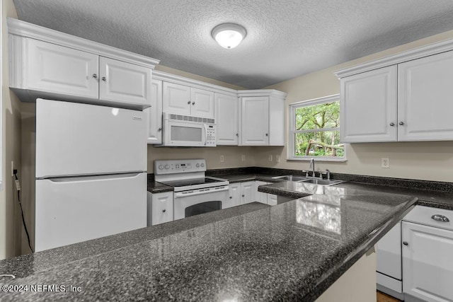 kitchen featuring a textured ceiling, white appliances, a sink, and white cabinets