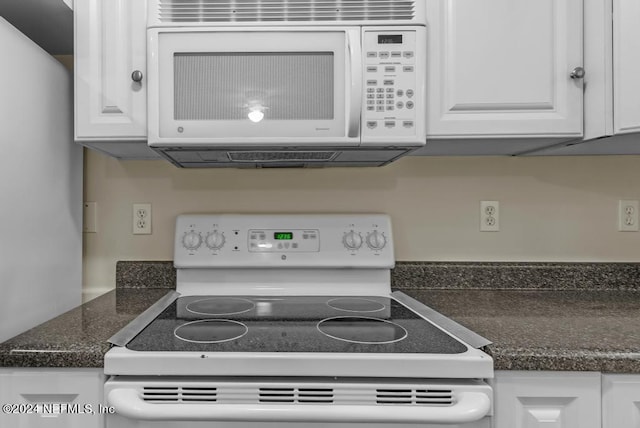 kitchen featuring dark countertops, white appliances, and white cabinets