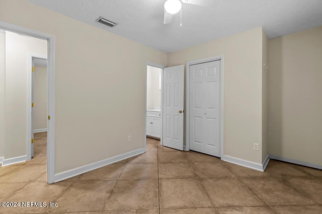 unfurnished bedroom featuring baseboards, visible vents, ceiling fan, a textured ceiling, and a closet