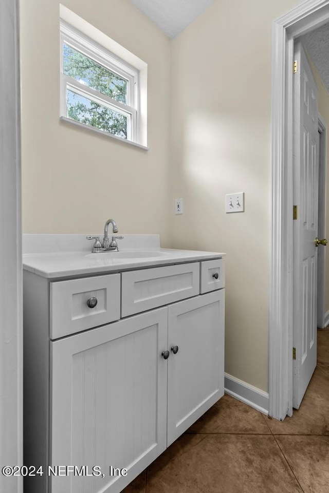 bathroom with tile patterned flooring, vanity, and baseboards